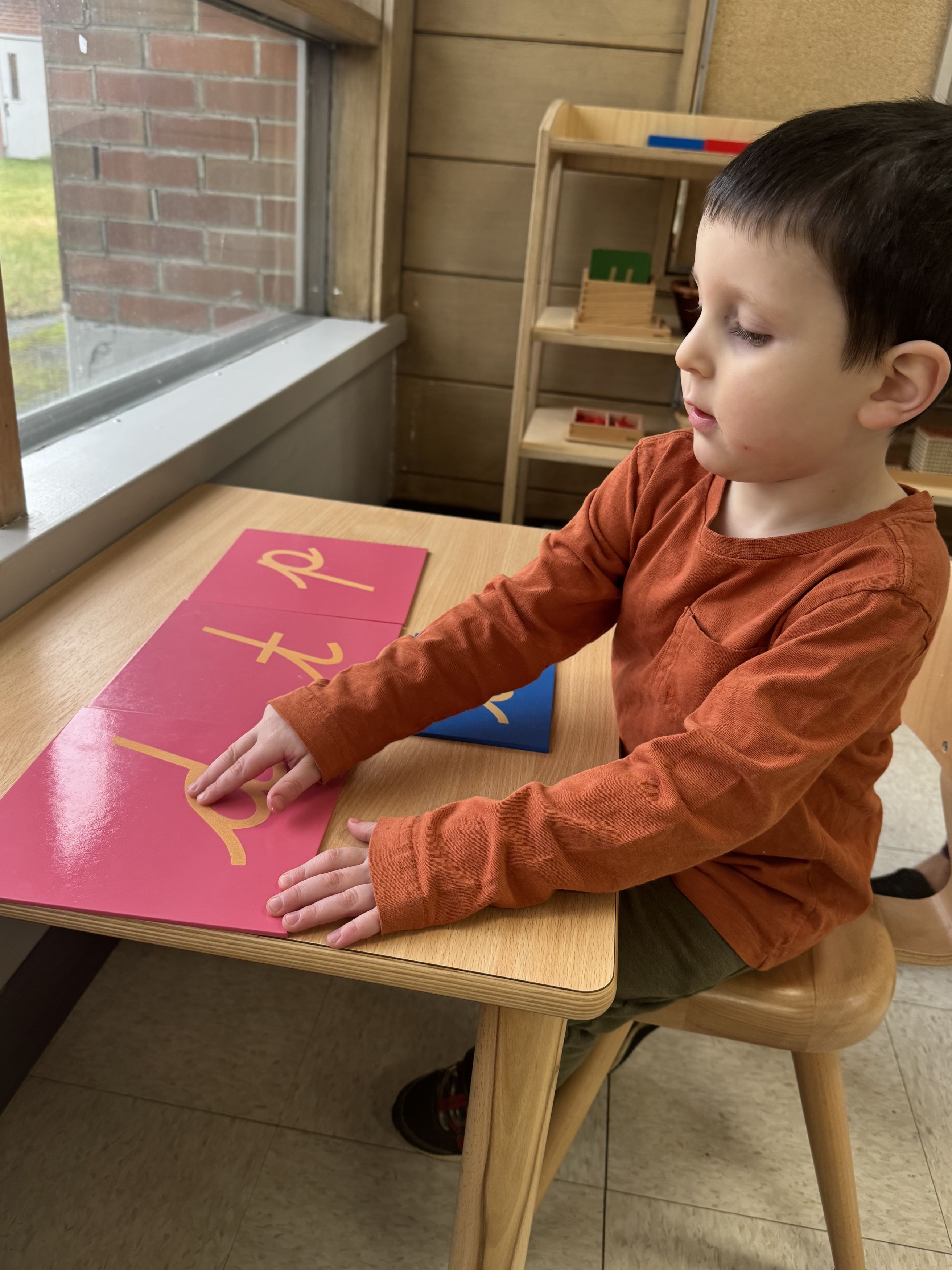 A Primary child tracing the sandpaper letters